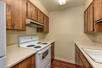 Kitchen with Hardwood Inspired Floors, Oven, Stove, Wood Cabinets and Sink Countertop